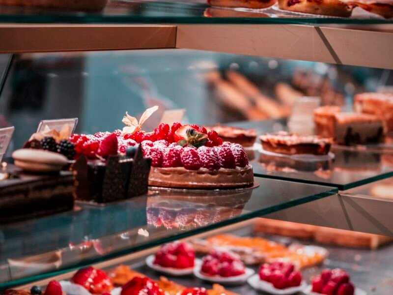 Fruit tarts and chocolate cakes in a bakery display